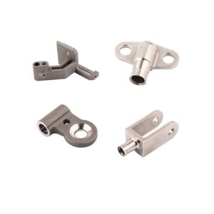 Four machined metal parts with distinct shapes and holes are shown on a white background.