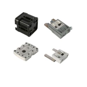 Four metal machine parts laid out in a grid on a white background.