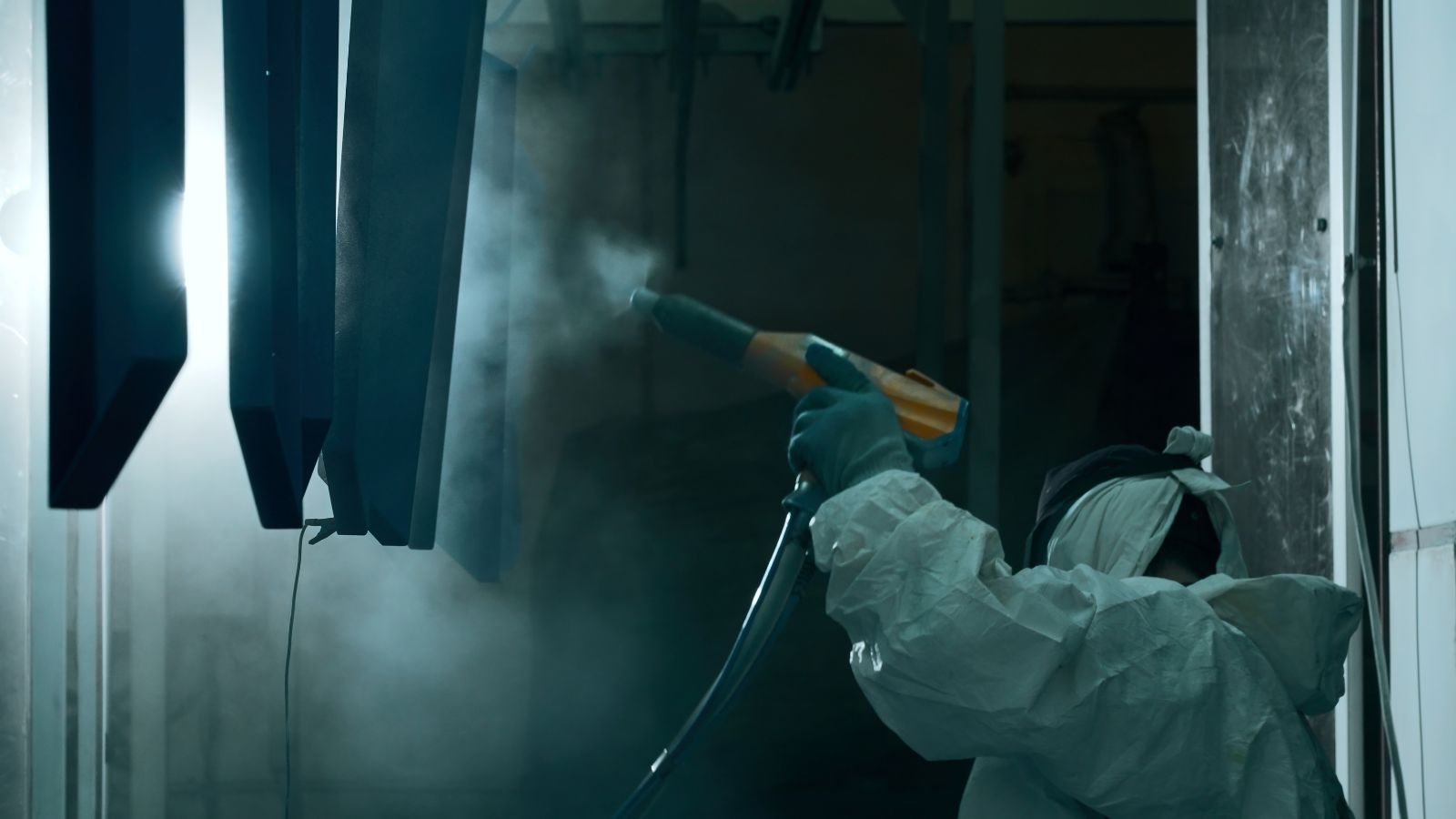 a worker performing powder coating for die casting surface finish