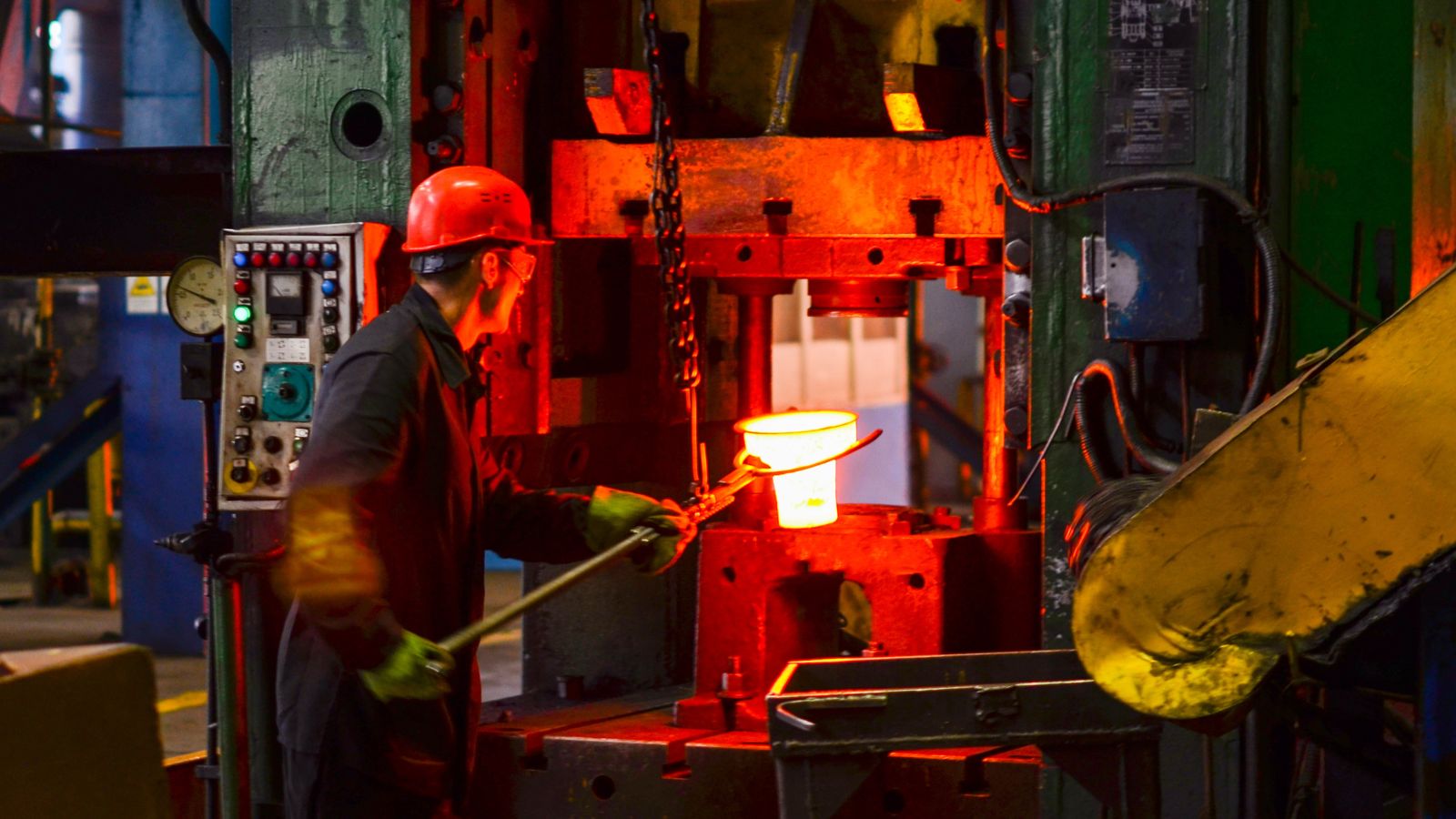 a worker performing hot forging process, showing drastic differences with die casting