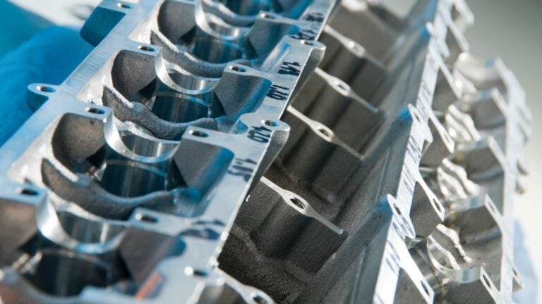 Close-up of a metal engine block mold used in die casting for engine manufacturing, showing detailed cavity and surface finish.