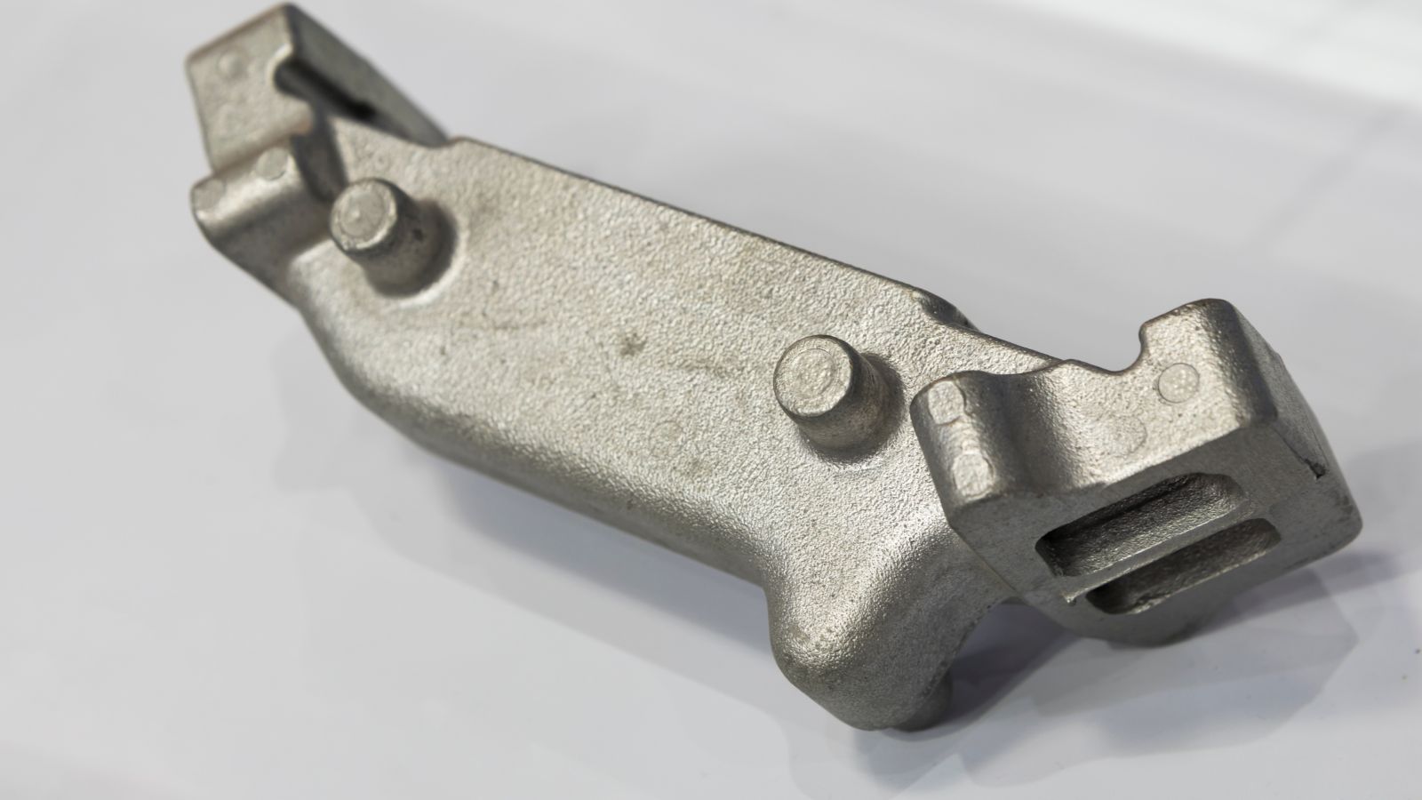 Close-up of a metallic aluminum die casting part with detailed surface texture and complex shape, used in manufacturing processes.
