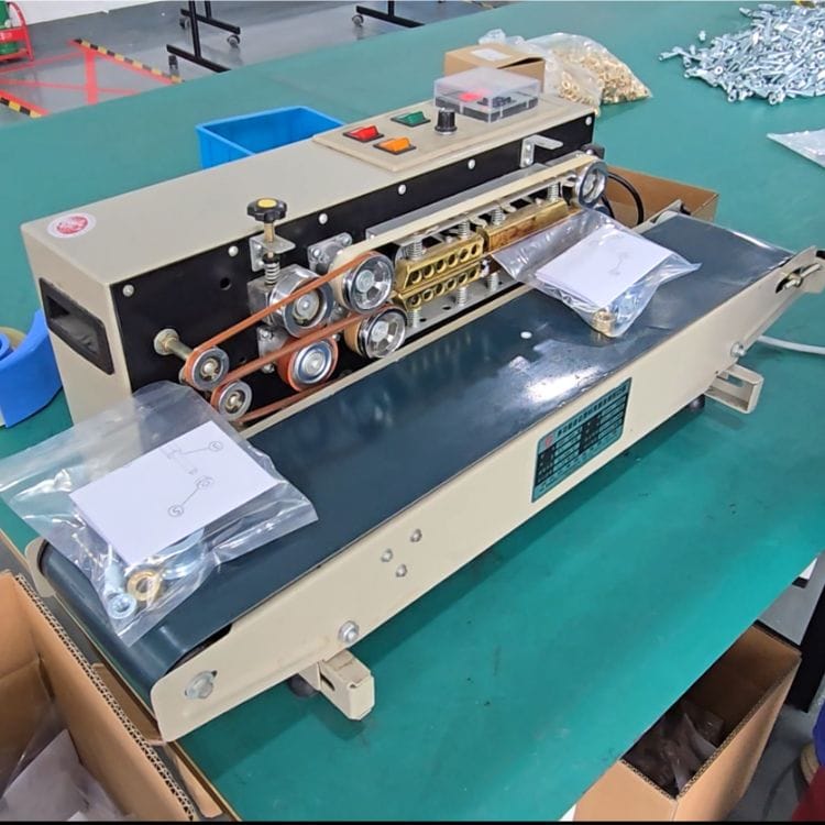 Close-up of metal casting machine with rollers and control panel in a manufacturing setting.